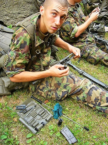 Cute rough soldier cleaning gun
